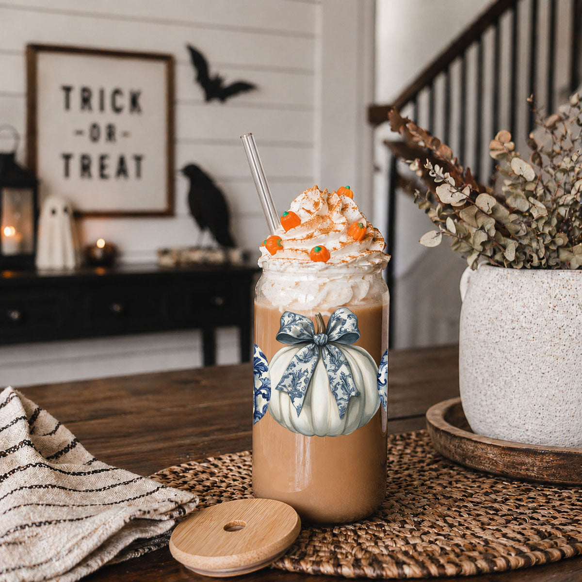 Halloween-themed drink with whipped cream and candy on a table with decorative elements.