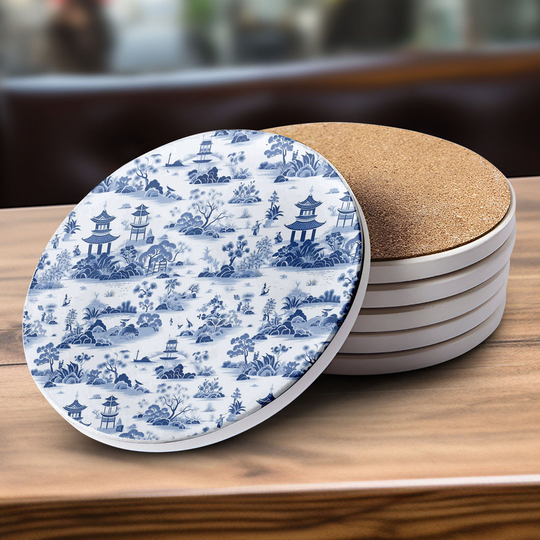 Set of coasters with blue and white pattern and cork backing on a wooden surface