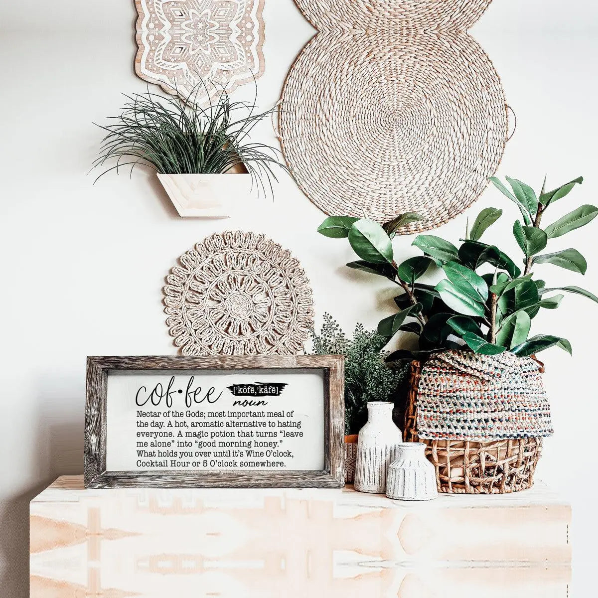 Decorative setup with plants, a framed definition of 'coffee', and woven baskets on a shelf.