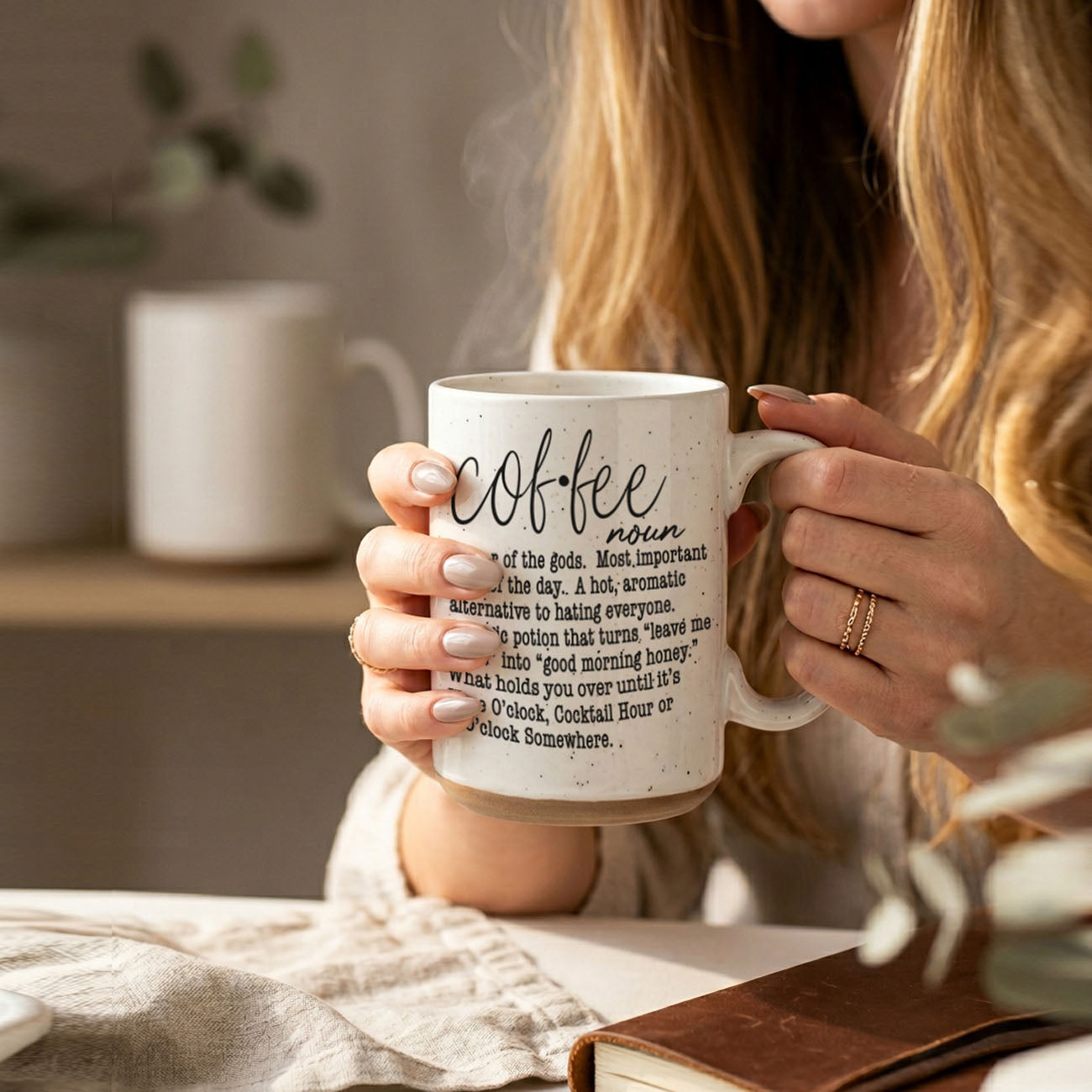 Person holding a mug with 'coffee' text in a cozy indoor setting