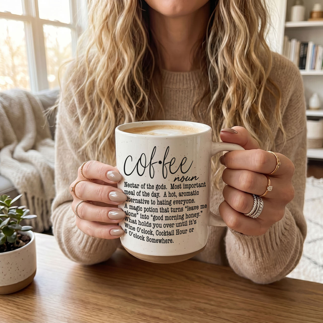 Person holding a mug with 'coffee' definition text in a cozy indoor setting