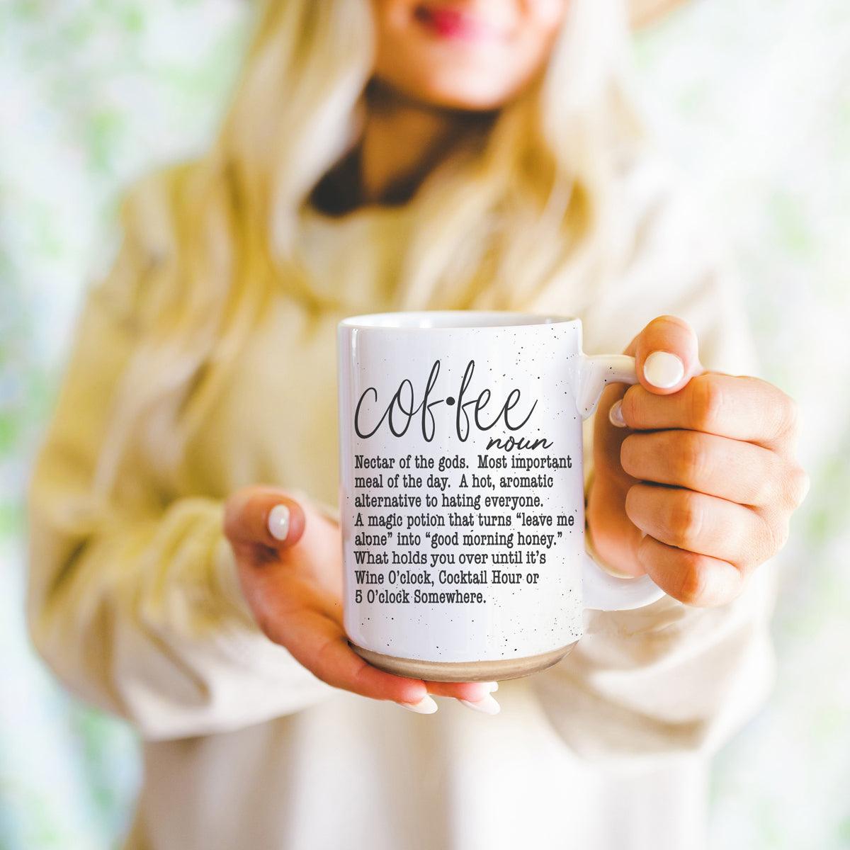 Person holding a mug with a coffee definition print