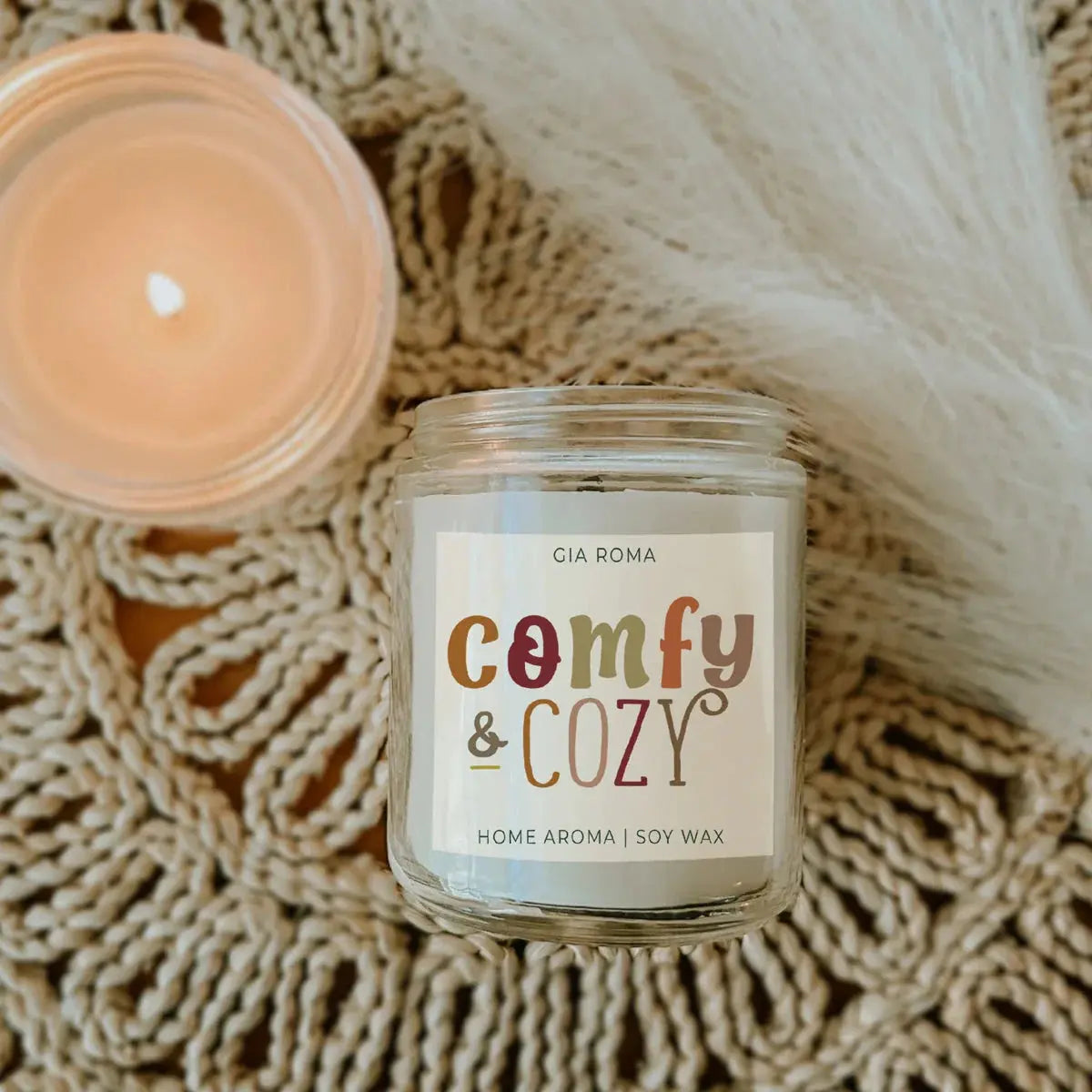 Candle jar labeled 'Comfy & Cozy' on a textured surface
