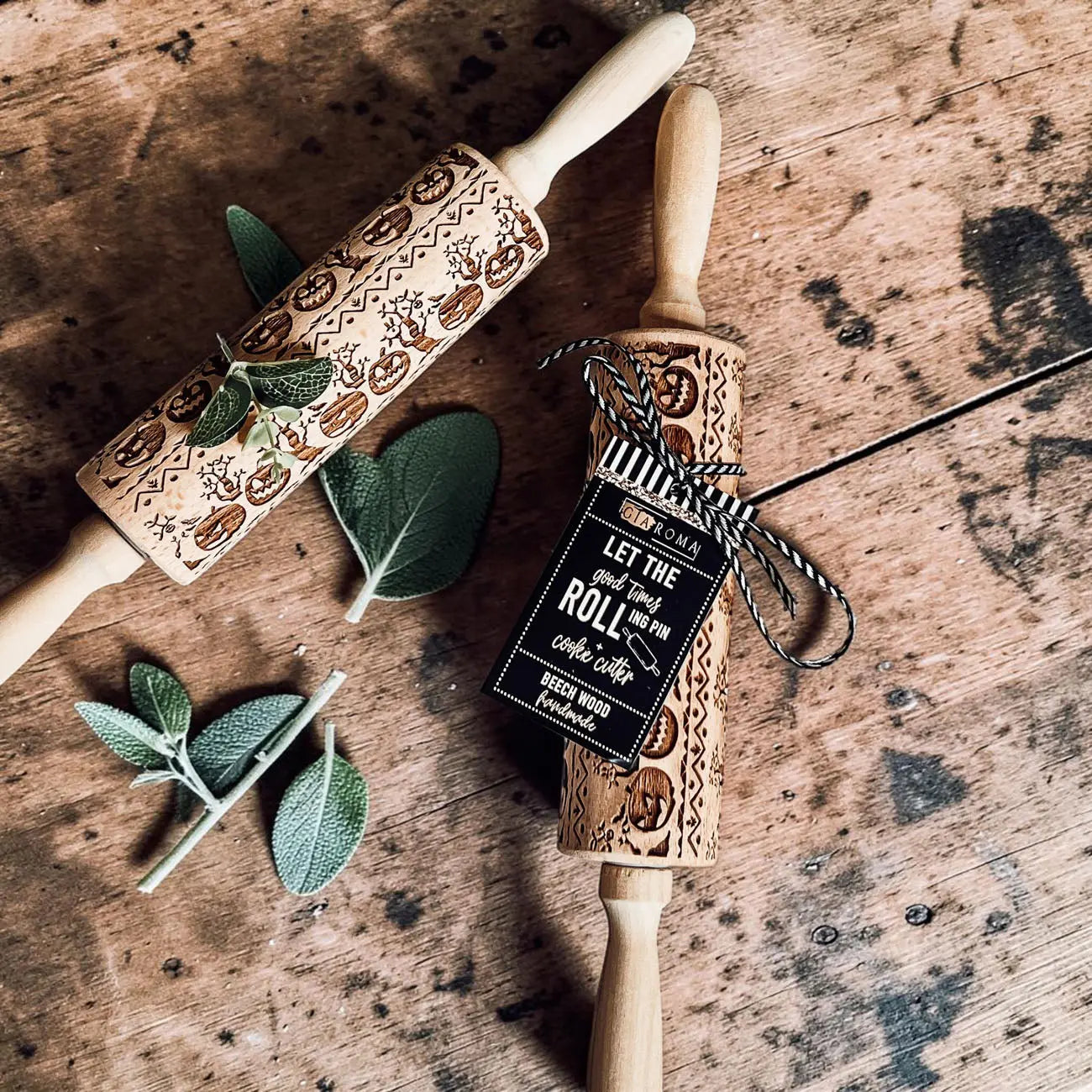 Two wooden rolling pins with embossed designs on a rustic wooden surface.
