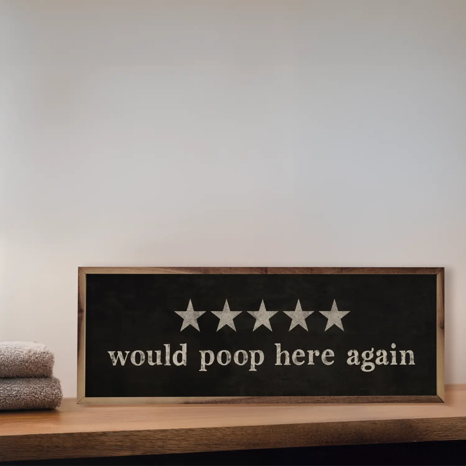 Wooden sign with five stars and text on a white wall