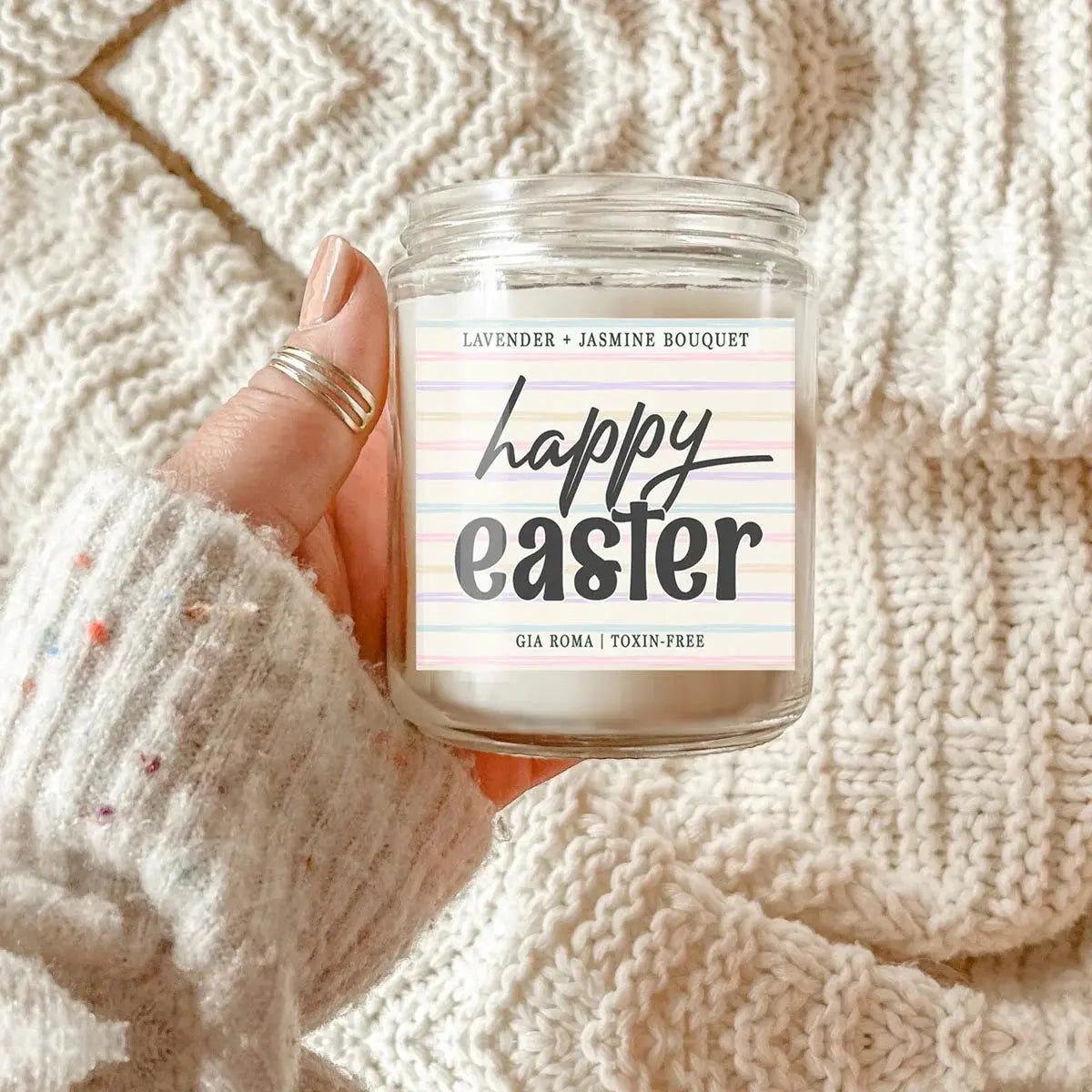 Candle labeled 'Happy Easter' held against a textured beige background