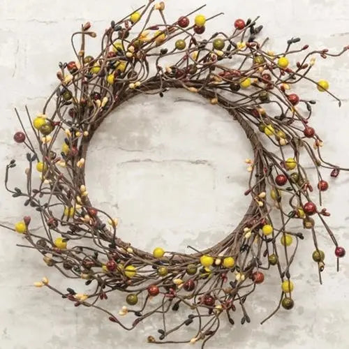 Wreath made of branches and small berries on a light background