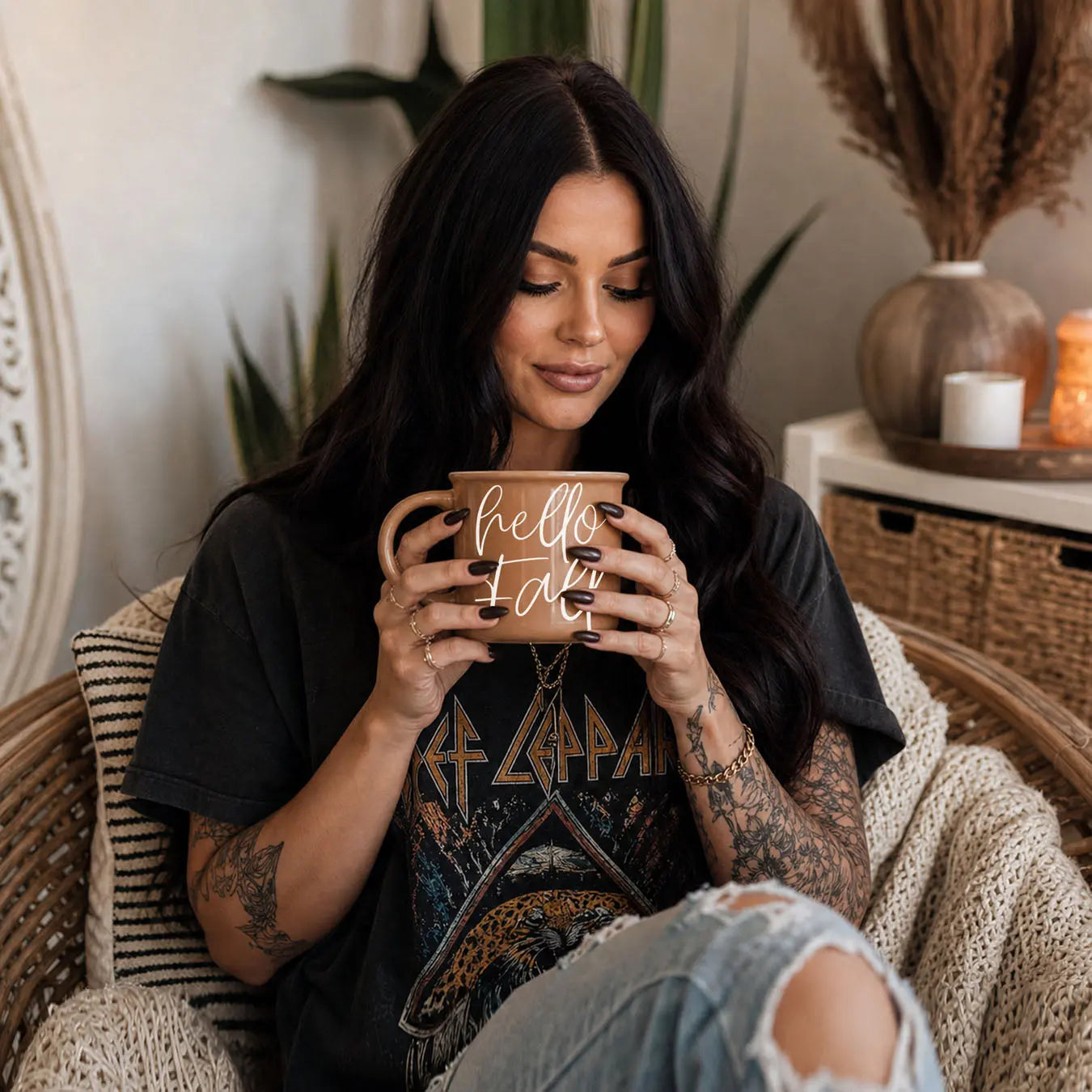 Woman holding a mug with 'sweater weather' text in a cozy indoor setting