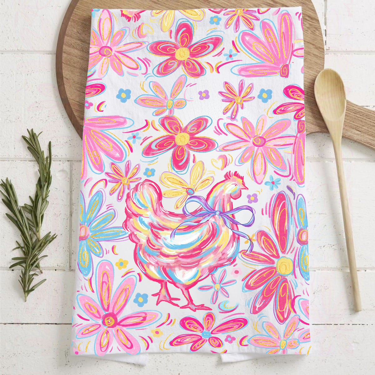 Colorful towel with rooster and floral design on a wooden surface