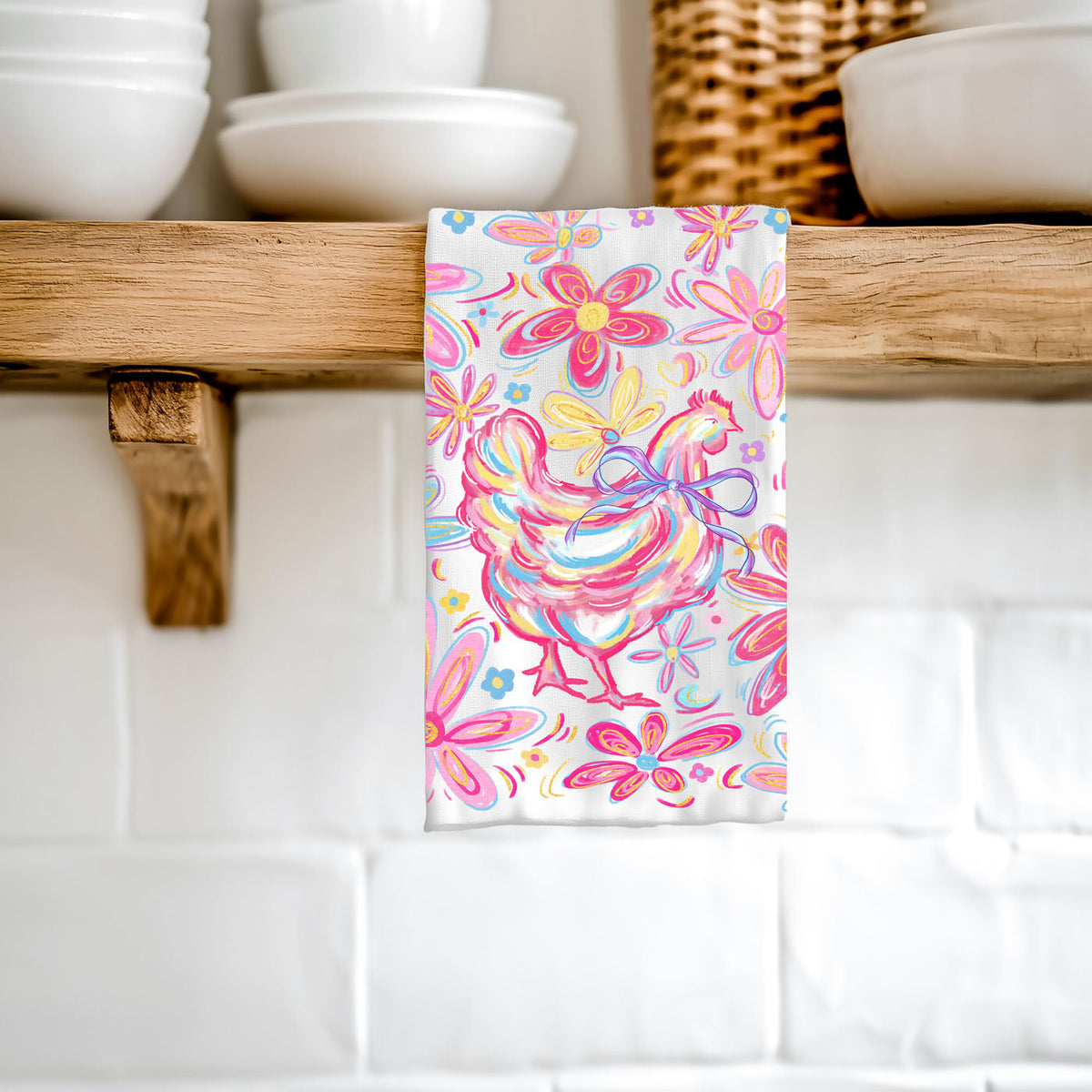 Colorful rooster towel hanging on a wooden shelf with kitchenware in the background