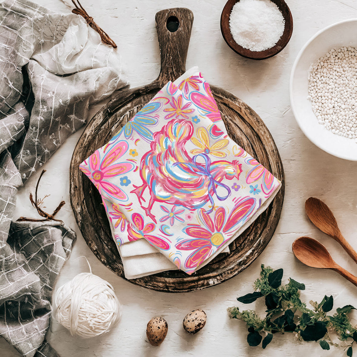 Colorful floral towel on a wooden plate with kitchen items around