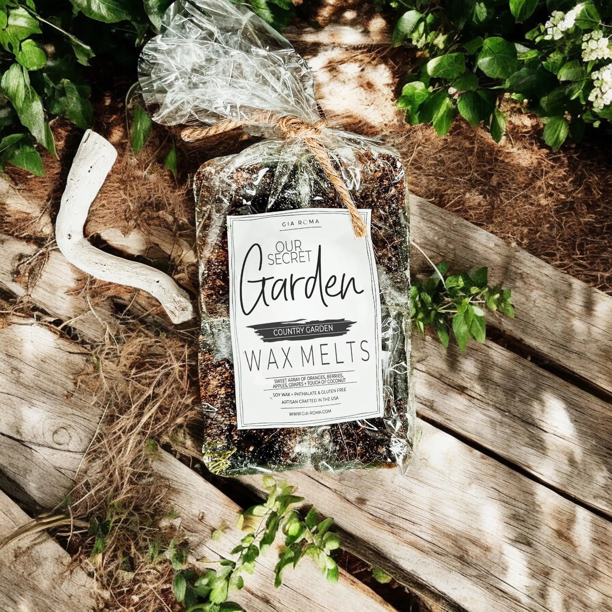 Packaged wax melts labeled 'Our Secret Garden' on a wooden surface with greenery.