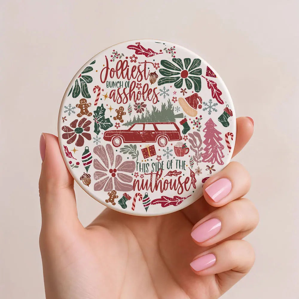 Round decorative item with Christmas-themed design held by a hand.