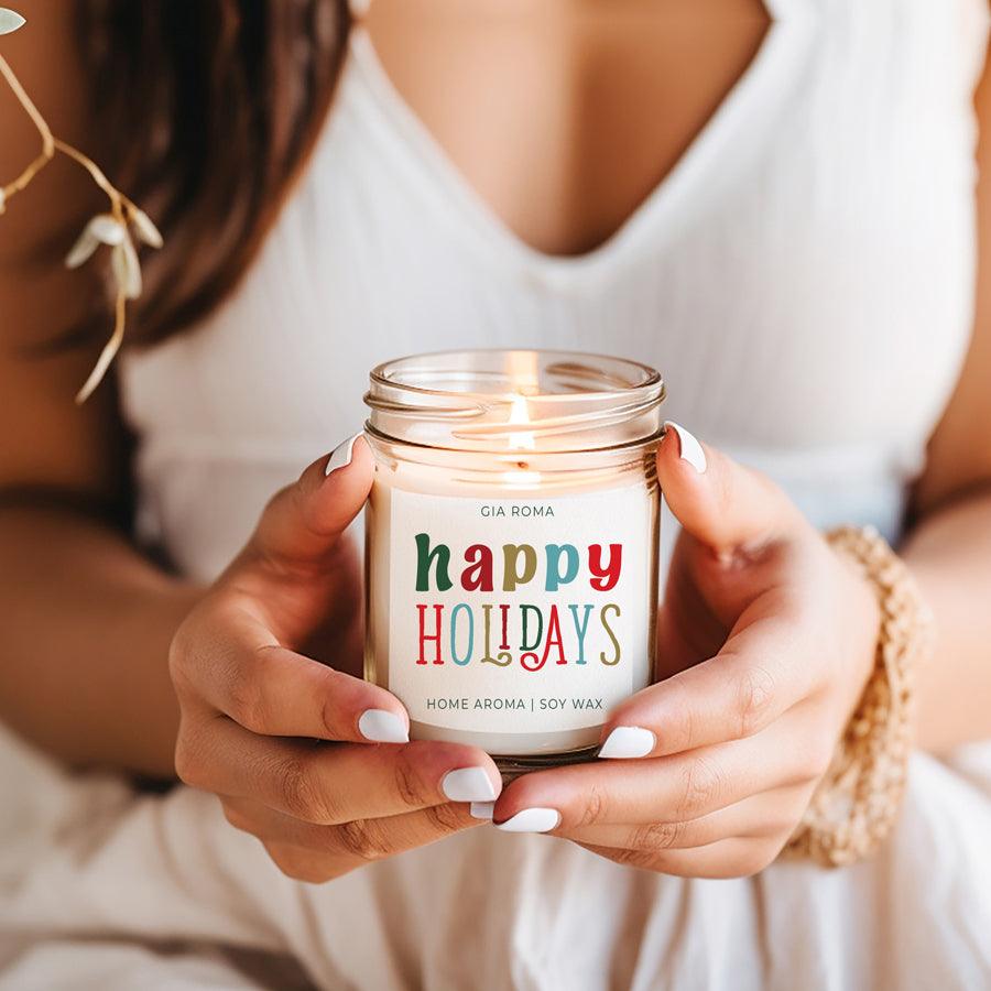 Person holding a lit candle labeled 'happy HOLIDAYS' with a colorful design.