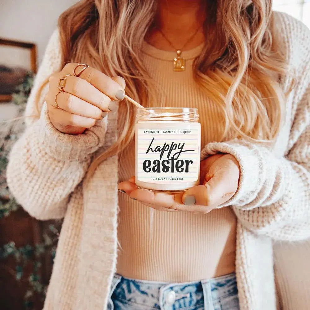 Person holding a 'Happy Easter' candle with a blurred background