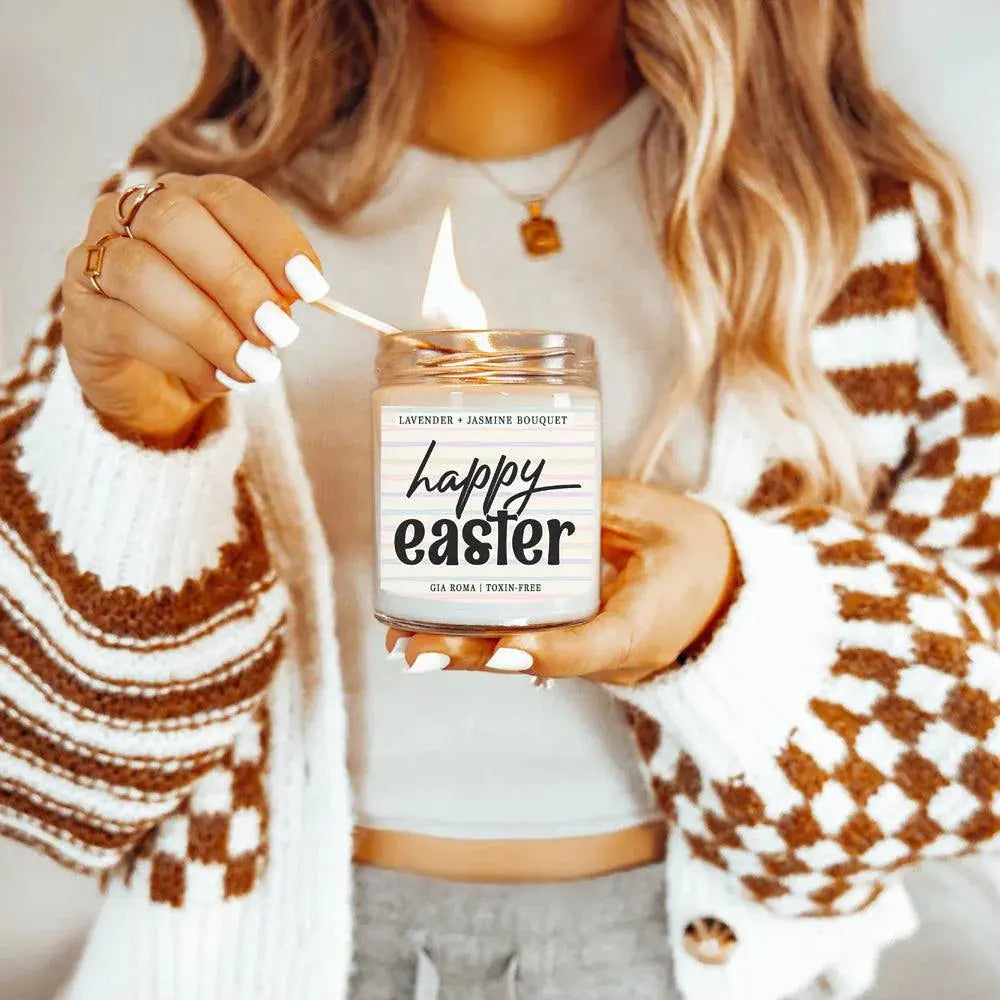 Person lighting a 'Happy Easter' scented candle
