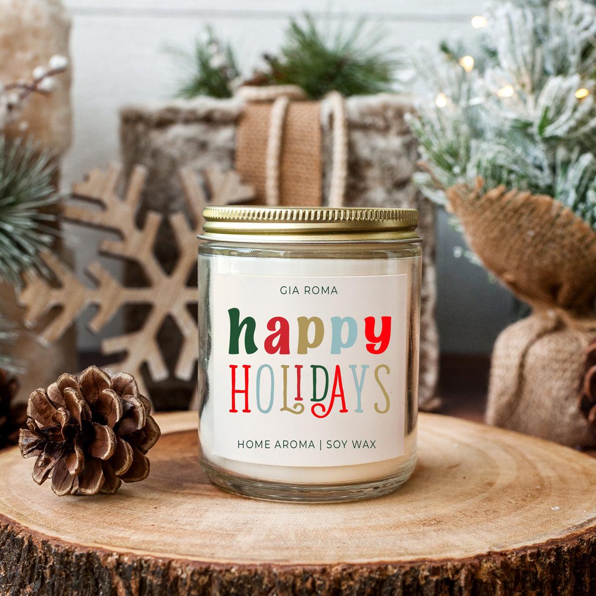 Candle jar labeled 'happy Holidays' on a wooden surface with festive decorations.