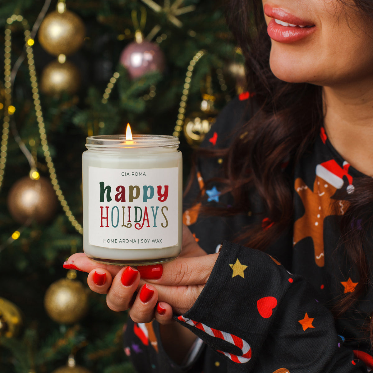 Person holding a 'happy holidays' candle in front of a decorated Christmas tree