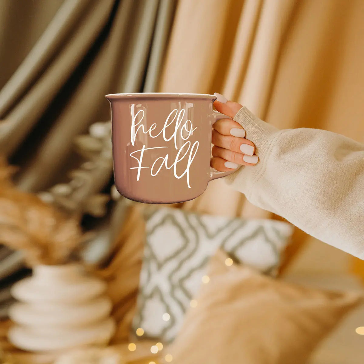 Person holding a mug with 'Fall is my 2nd favorite f-word' text in a cozy indoor setting.