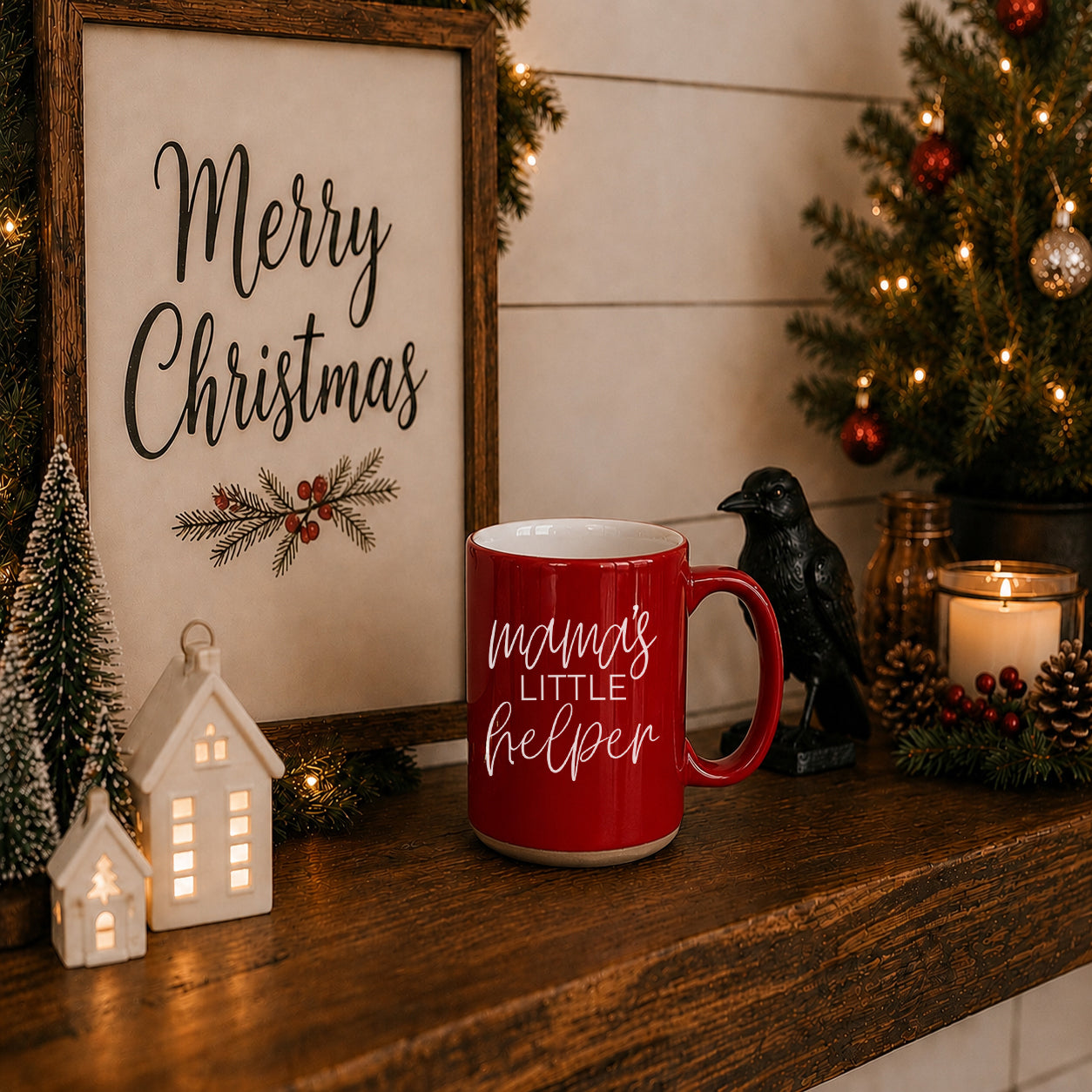 Red mug with 'mama's little helper' text on a Christmas-themed shelf with decorations.