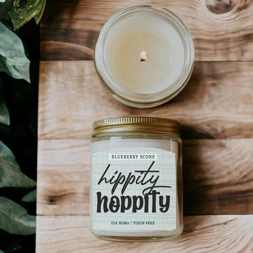 Hippity Hoppity candle jar with a lit candle on a wooden surface