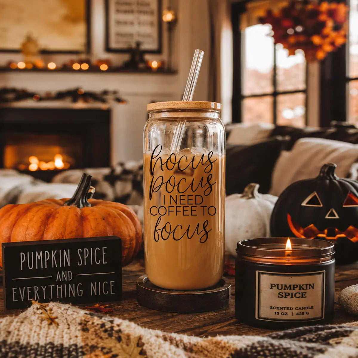 Glass jar with pumpkin spice coffee, straw, and Halloween decorations in a cozy room.