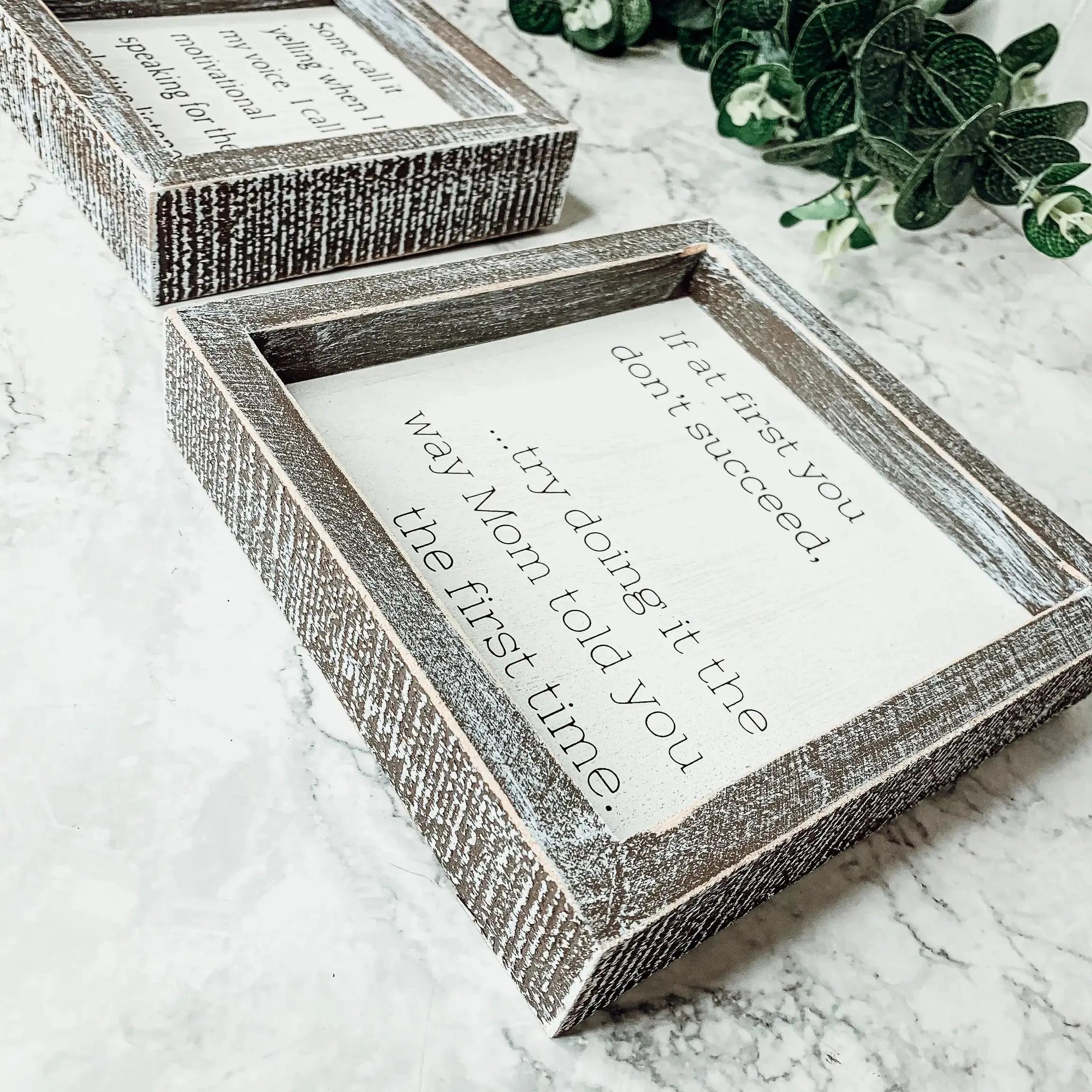 Decorative wooden box with text on a marble surface