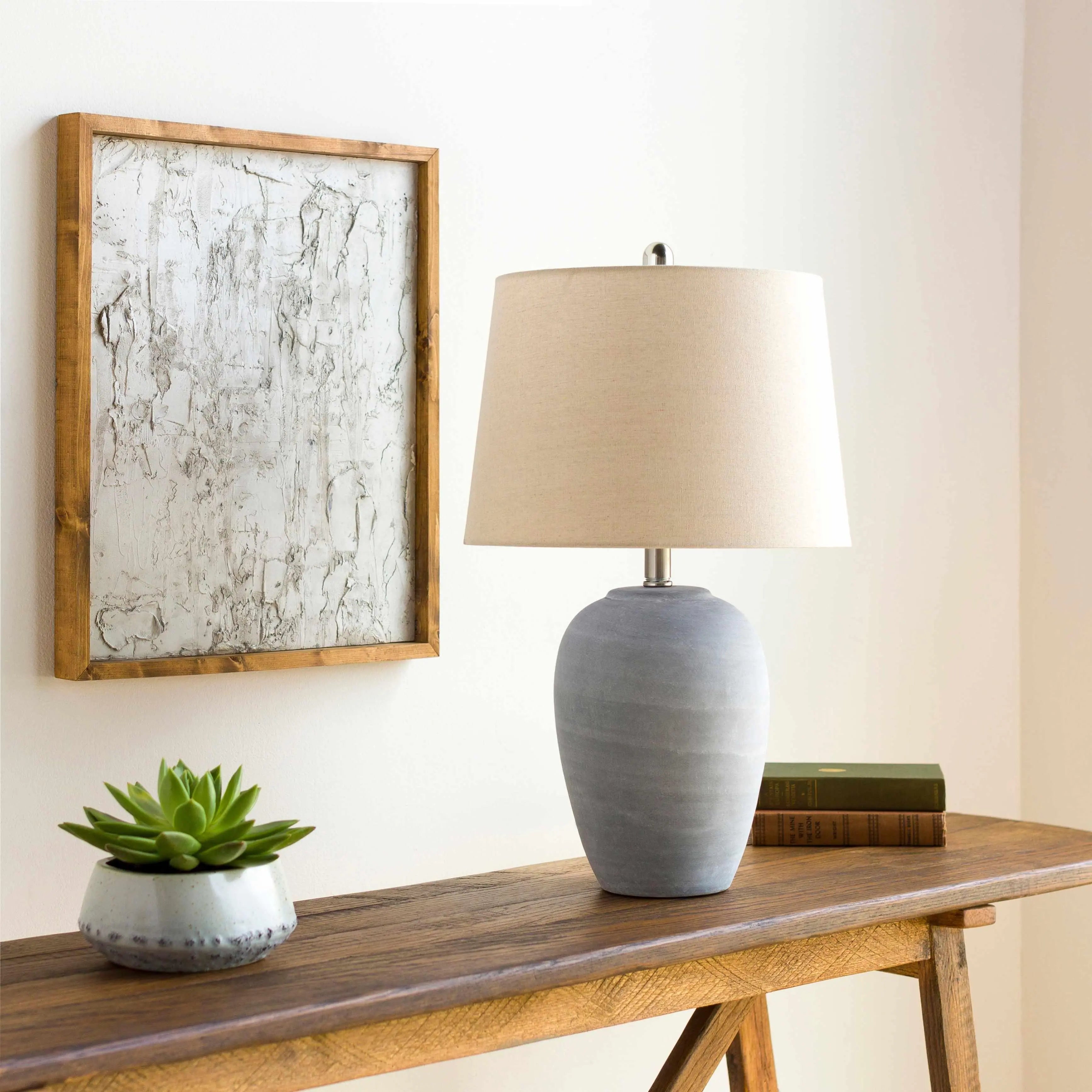 Gray ceramic table lamp with beige shade on wooden console table, farmhouse decor with succulent and framed art
