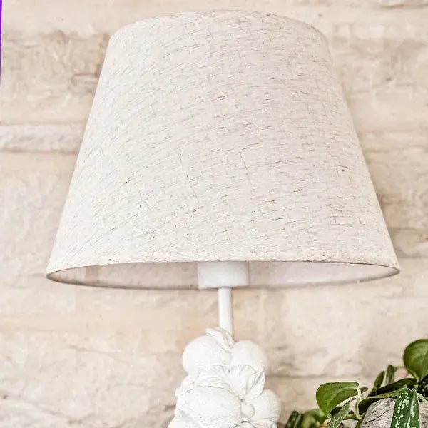 White textured lampshade on floral base, cozy farmhouse decor with green plant accent