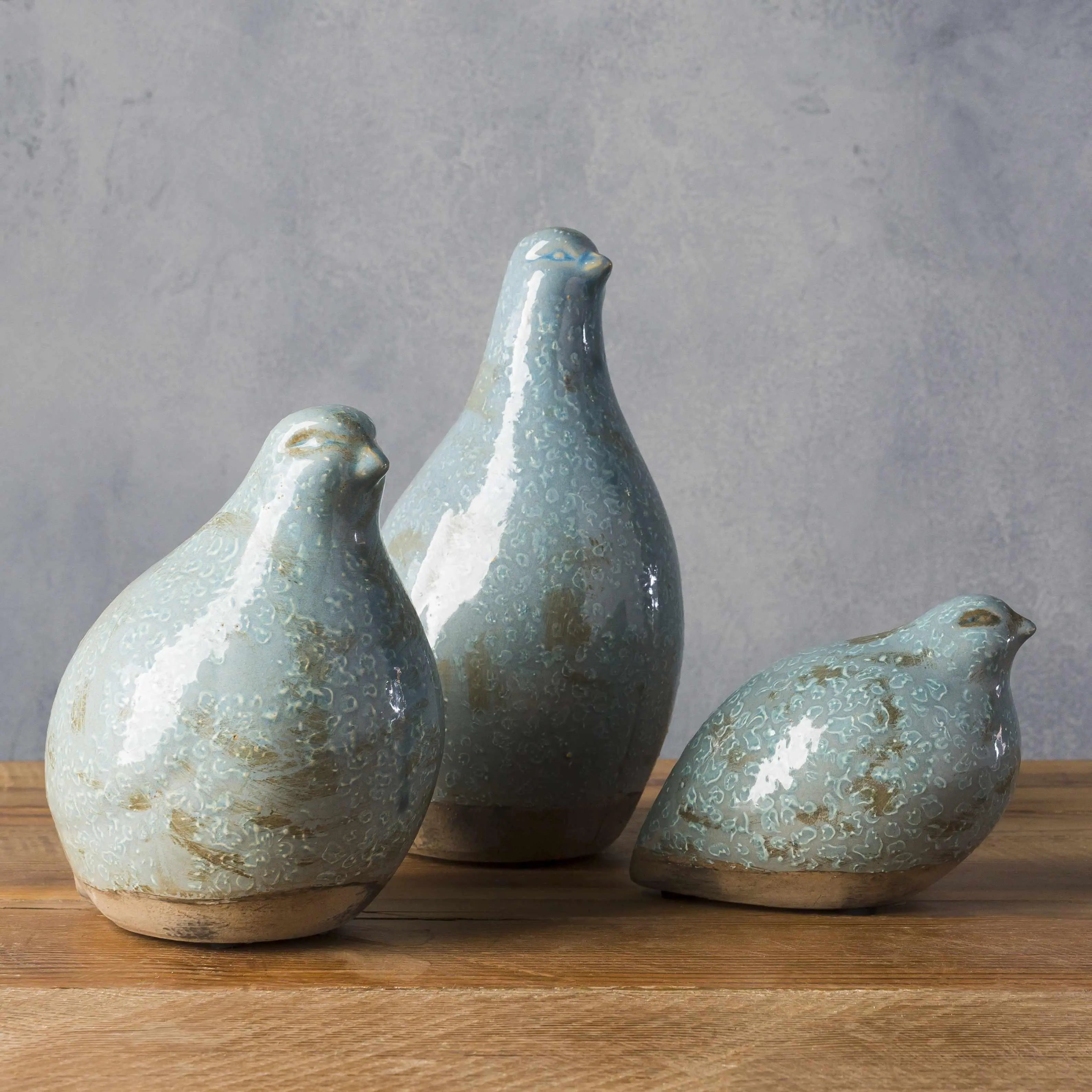 Set of three blue ceramic bird figurines for farmhouse or cottage home decor on wooden surface