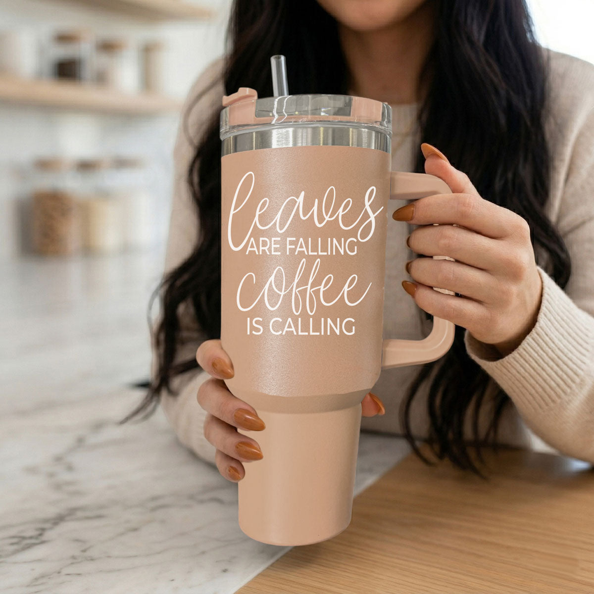 Person holding a pink tumbler with 'Leaves are falling, coffee is calling' text.