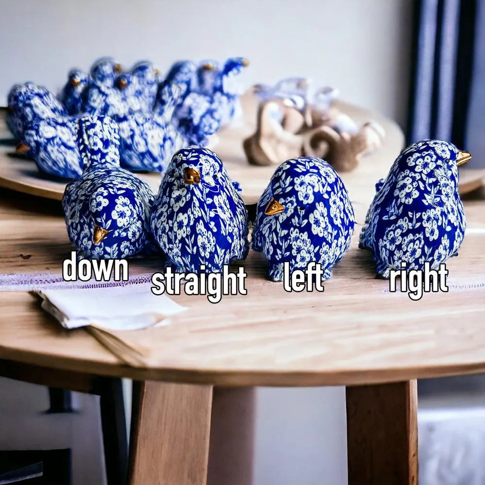 Blue and white ceramic birds on a wooden table with directional text.