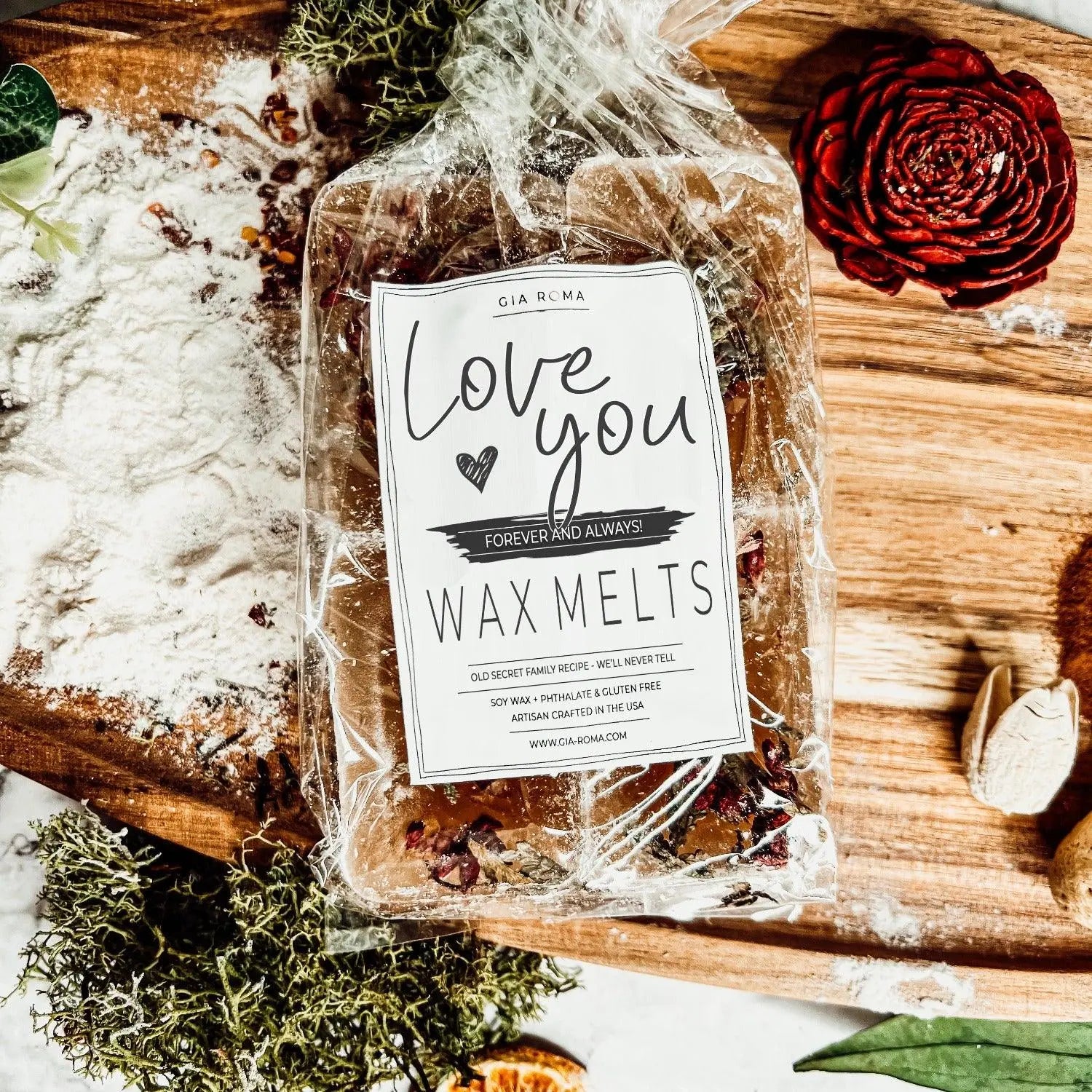 Packaged wax melts with a decorative label on a wooden surface with greenery.
