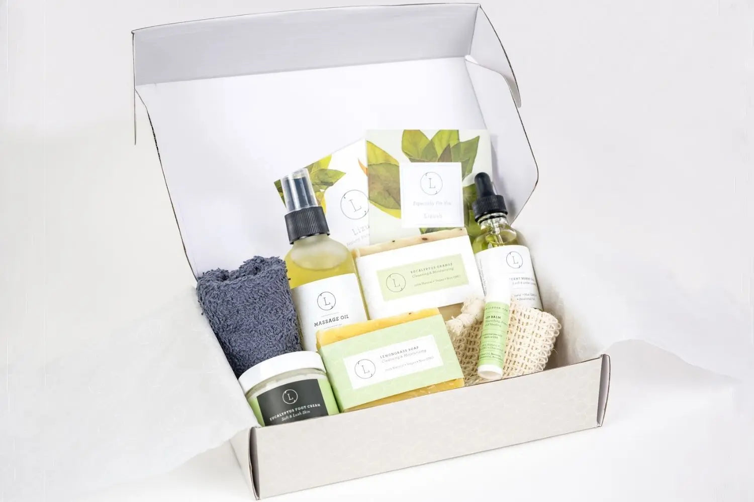 Cozy bath & body gift set with massage oil, soaps, foot cream, and loofah in farmhouse-style packaging