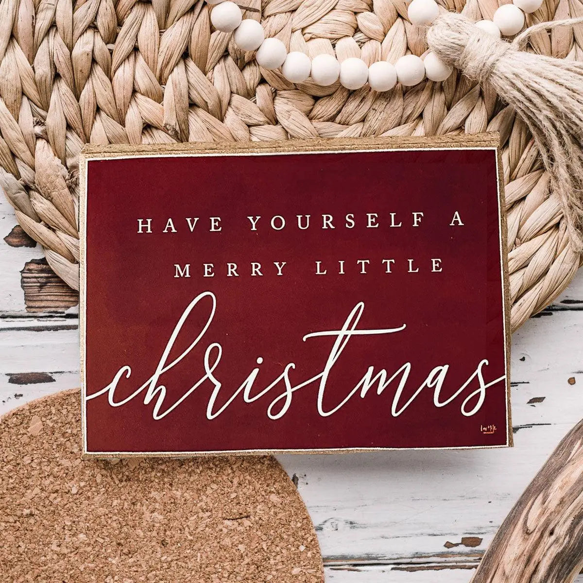 Decorative sign with 'Have Yourself a Merry Little Christmas' text on a rustic background.