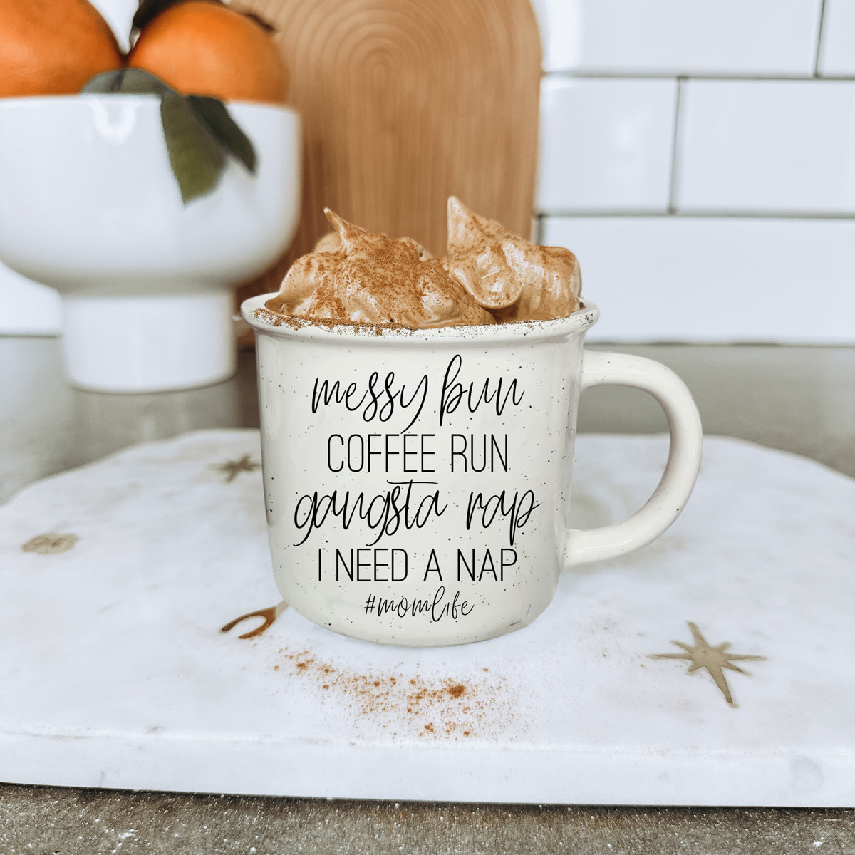 Mug with text on a kitchen counter with cinnamon chips and oranges.
