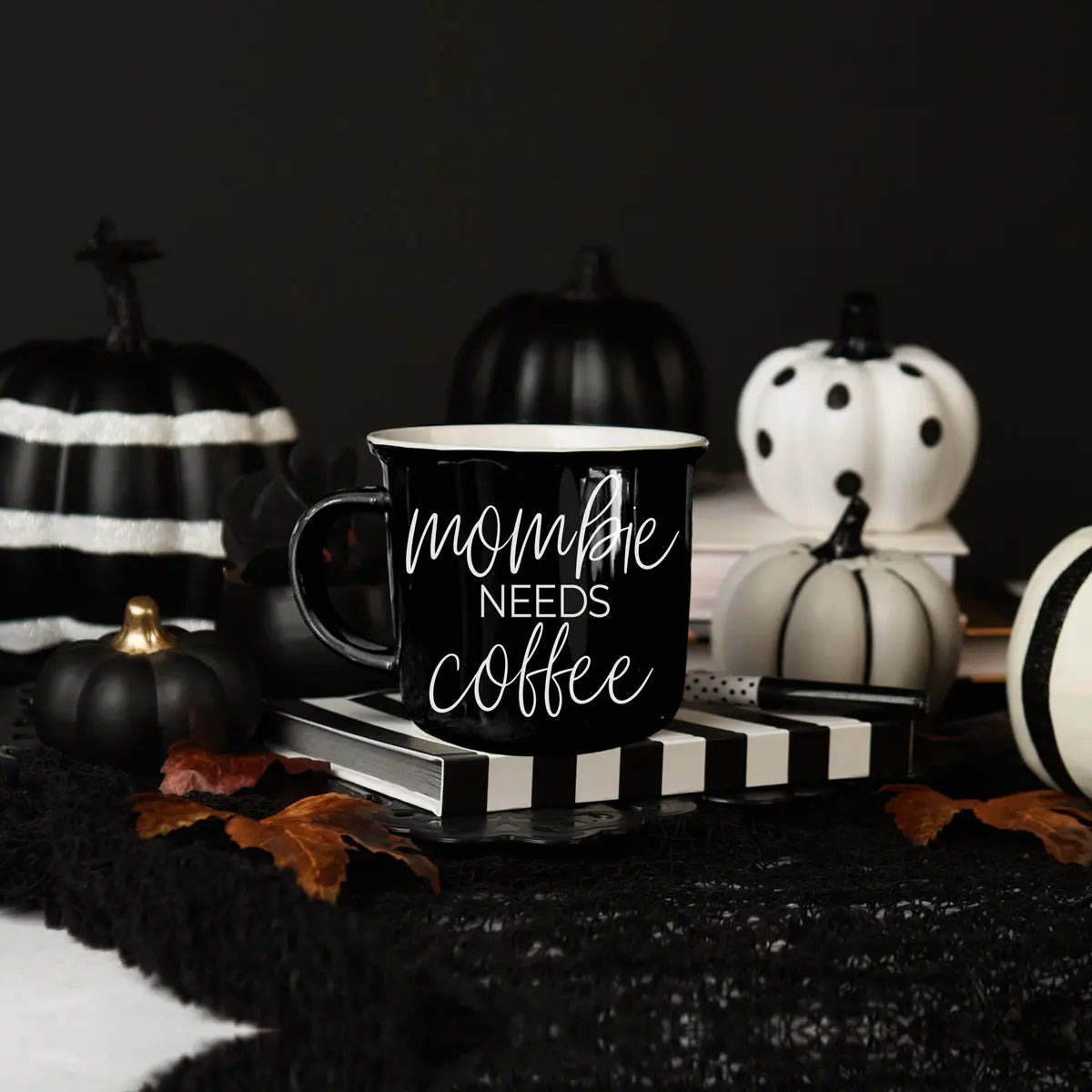 Black mug with 'Spooky Season' text on a dark background with Halloween decorations.