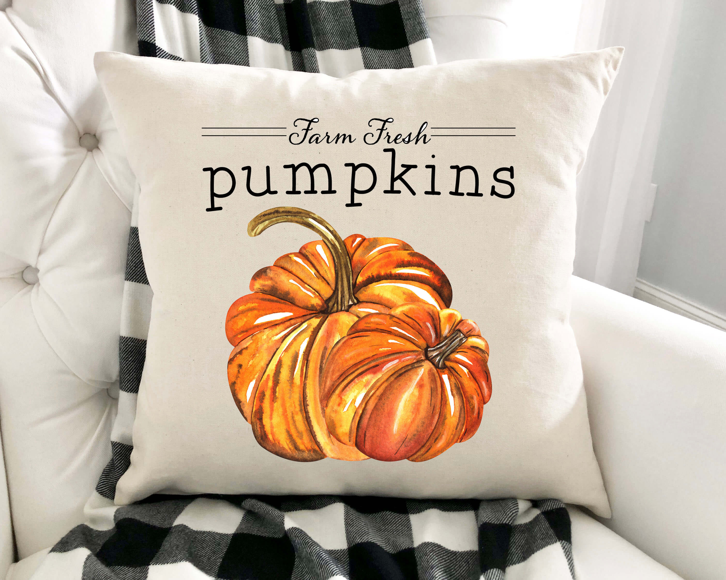 Decorative pillow with a pumpkin design and 'Farm Fresh Pumpkins' text on a white couch.