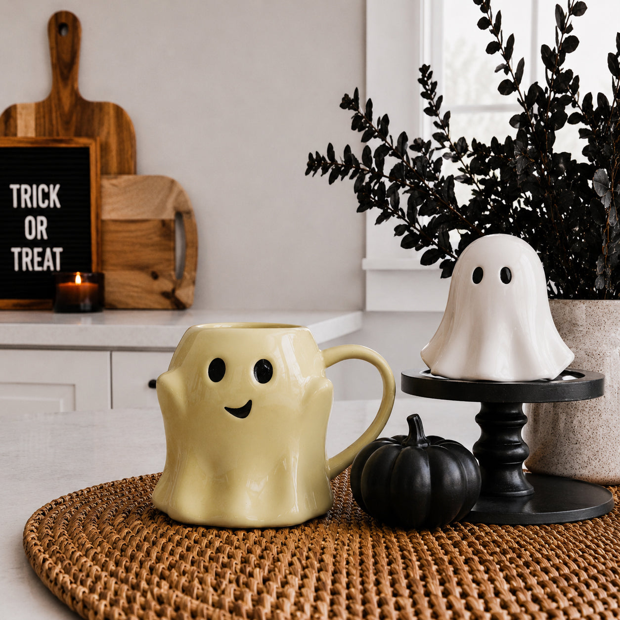 Halloween-themed ghost mug and decorative ghost on a table with pumpkins and 'Trick or Treat' sign.