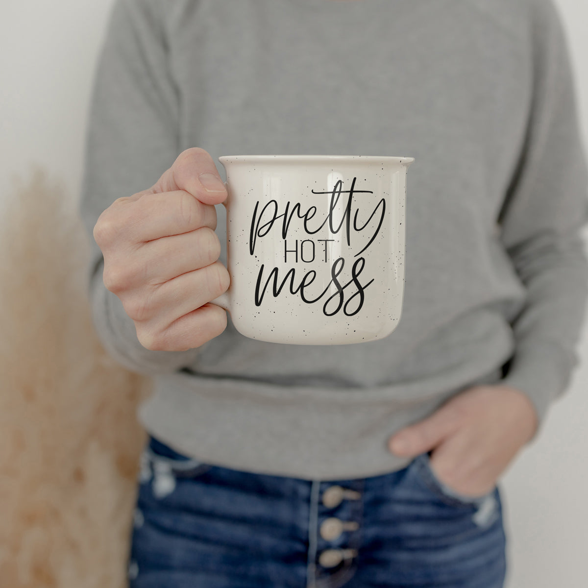 Person holding a mug with 'pretty hot mess' text