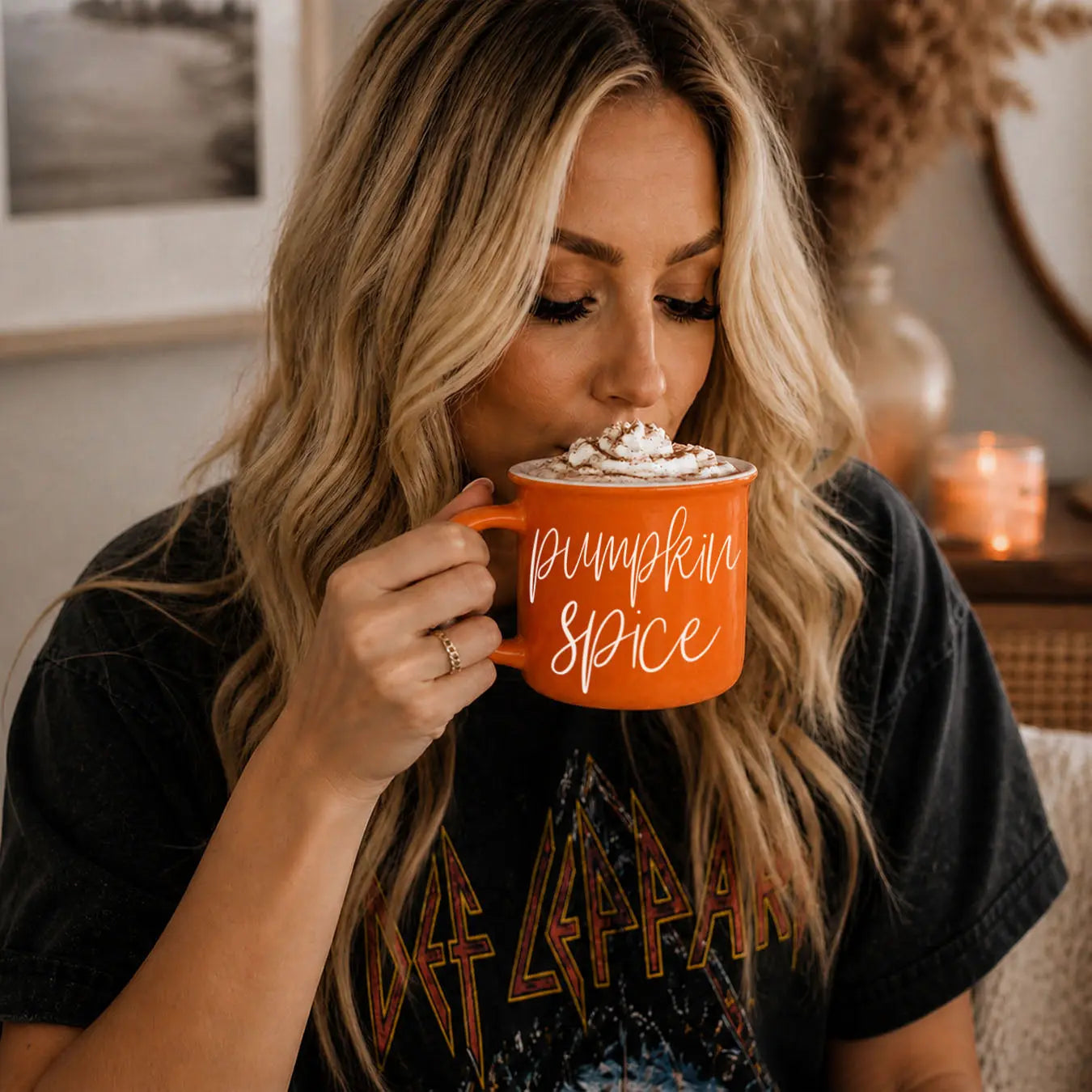 Woman drinking from a 'Pumpkin Spice' mug in a cozy indoor setting