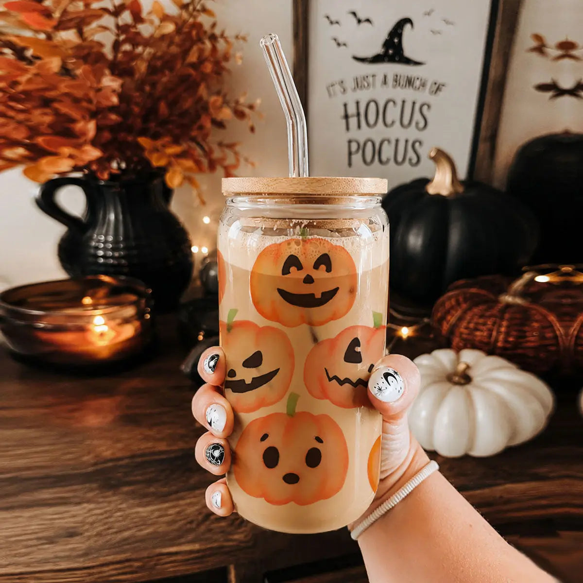 Hand holding a mason jar with a humorous quote, surrounded by Halloween decorations.