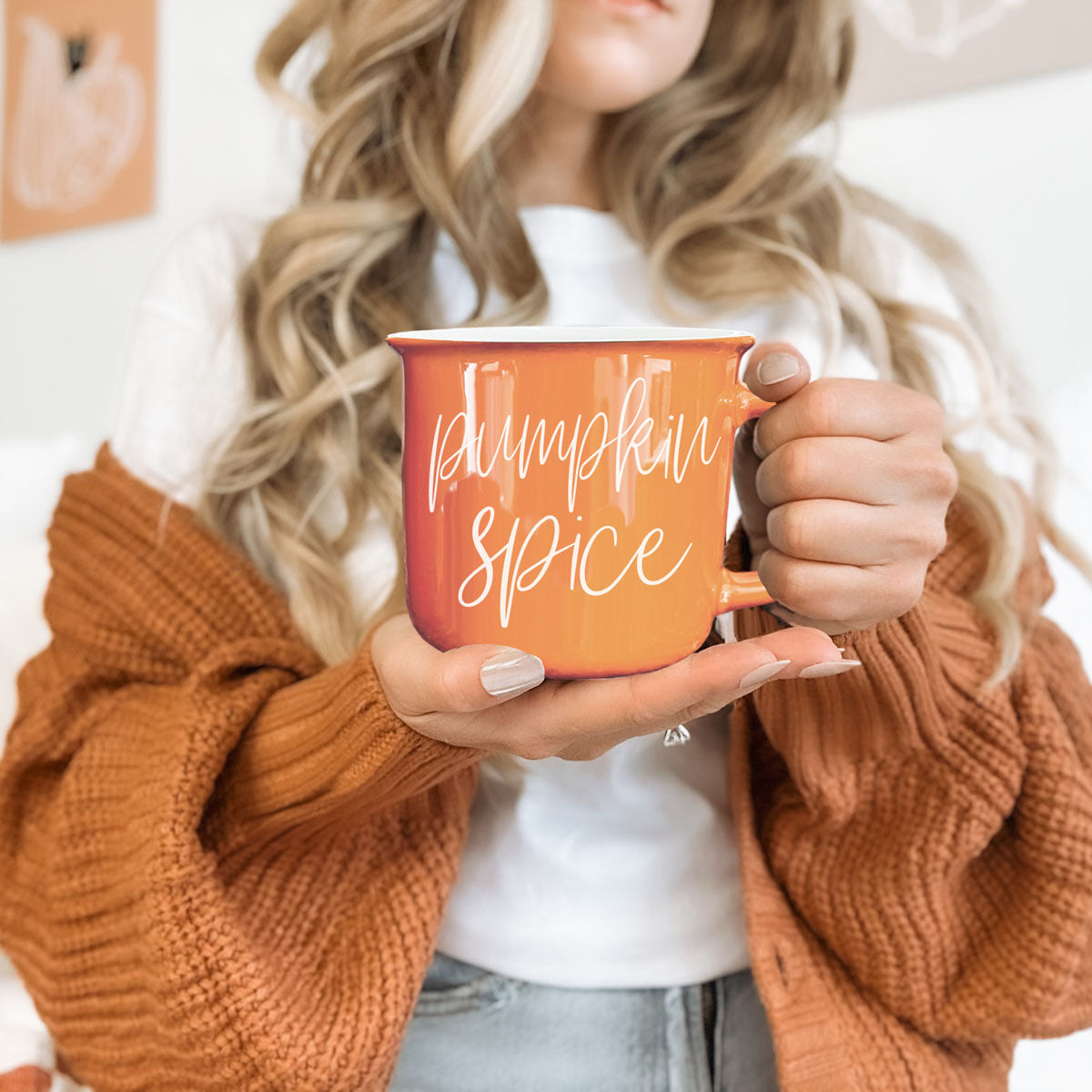 Person holding an orange mug with 'I hate pumpkin spice, yeah, I said it' text.