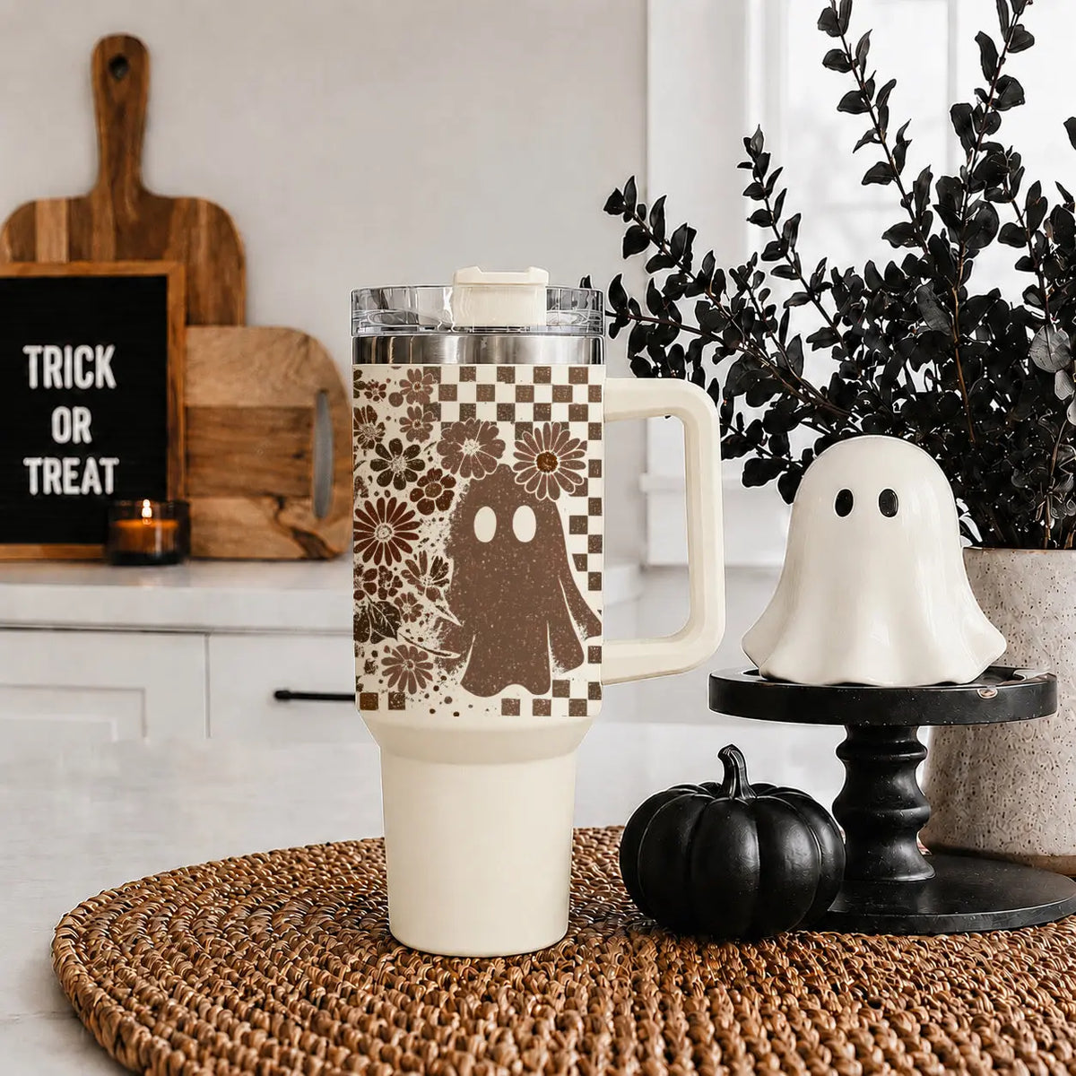 Halloween-themed mug with ghost design on a table with decorative items.