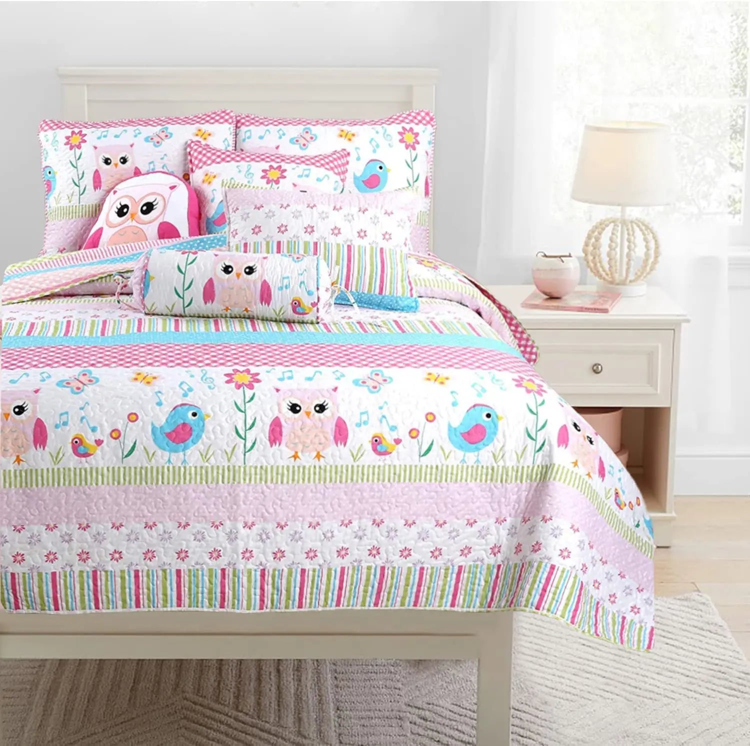 Home Sweet pink owl print reversible quilt bedding set with colorful striped design and coordinating decorative pillows for a girl's bedroom.