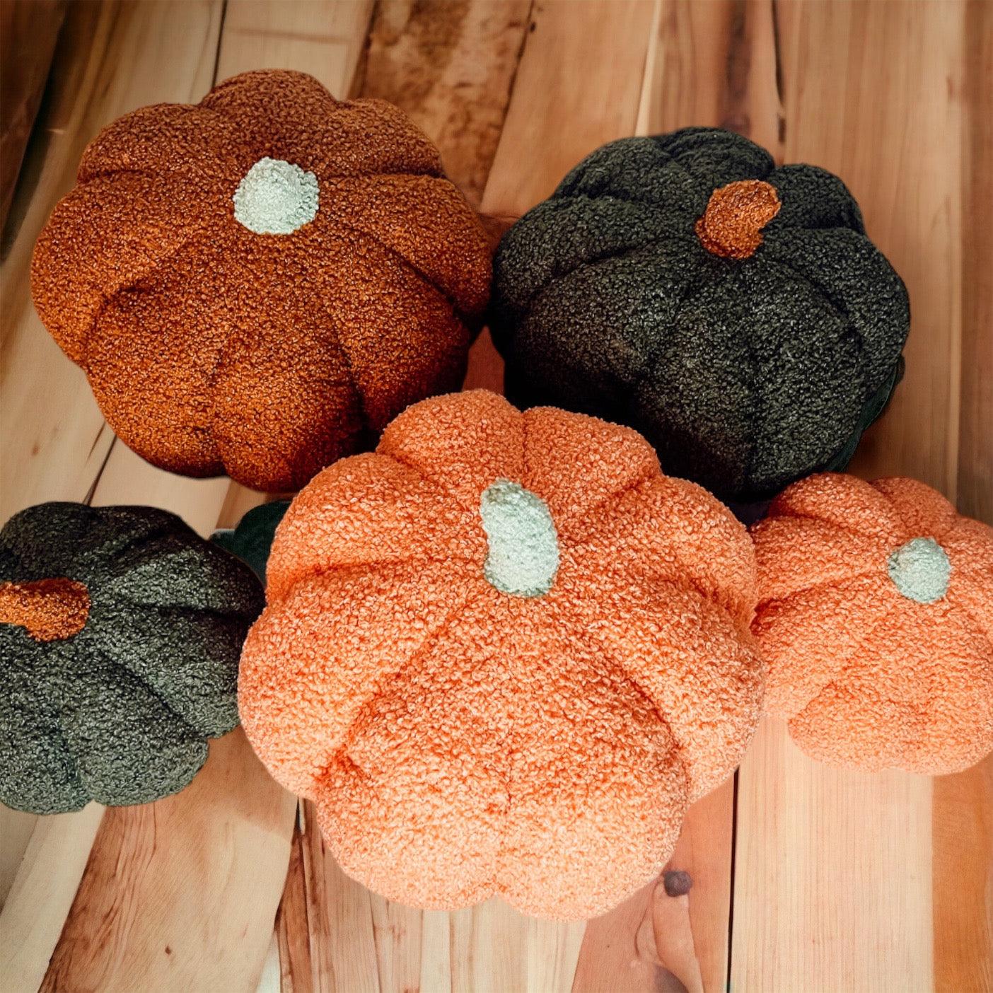 Knitted pumpkins in orange and black on a wooden surface