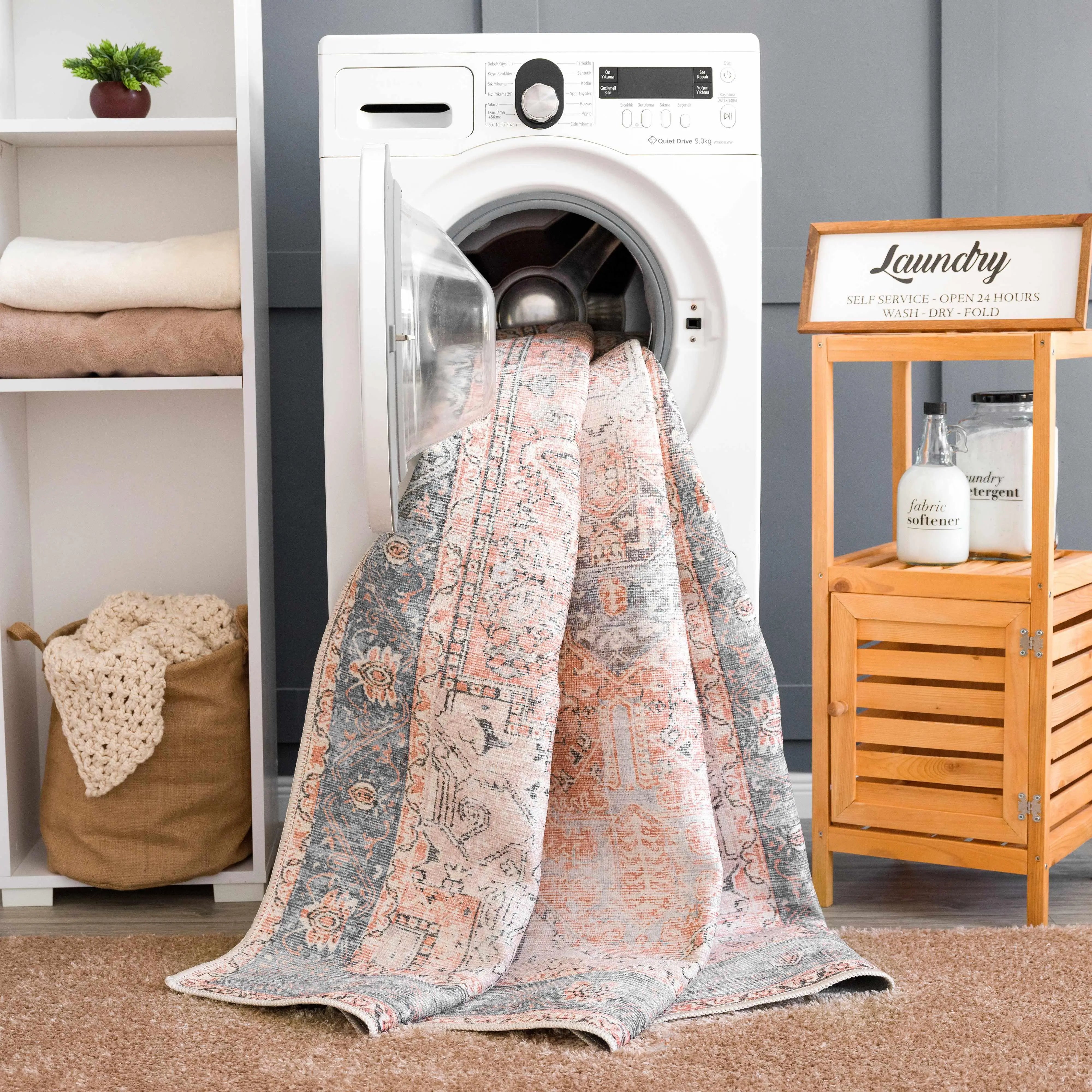 Cozy farmhouse-style blanket with vintage pattern draped from washing machine in laundry room