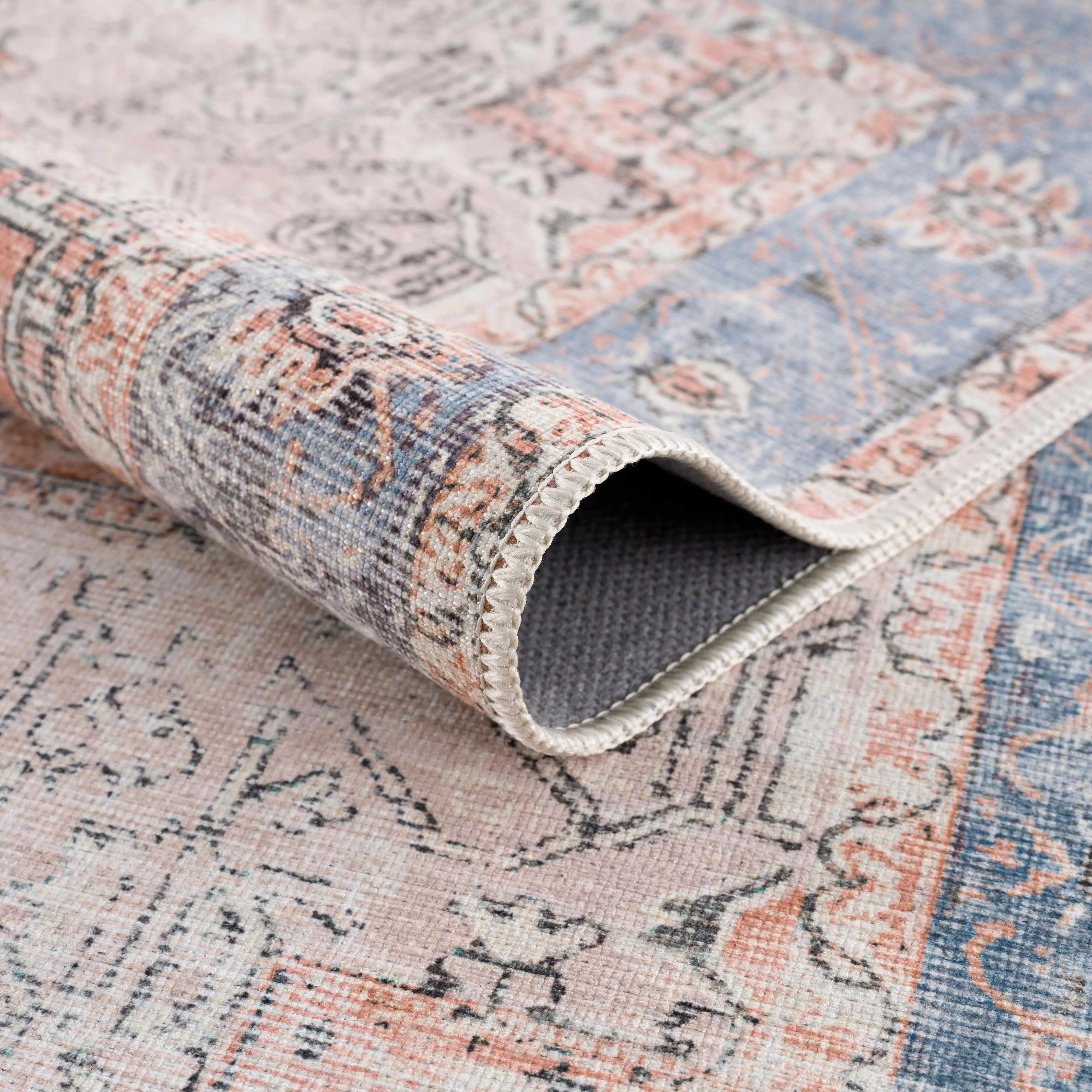 Vintage-style area rug with pastel floral patterns and soft blue-pink hues for cozy farmhouse decor
