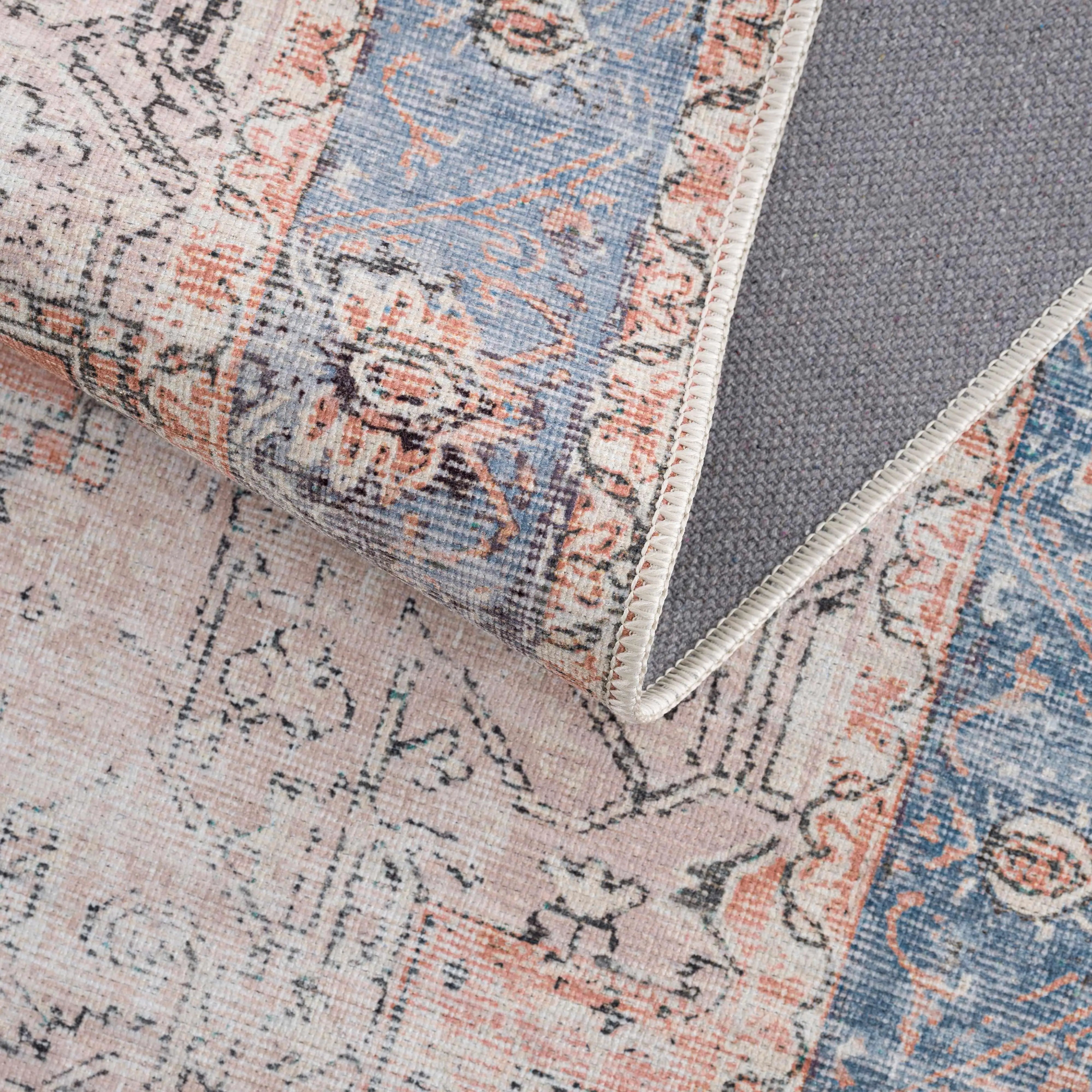 Vintage-style area rug with blue, pink, and gray floral patterns, ideal for cozy farmhouse decor