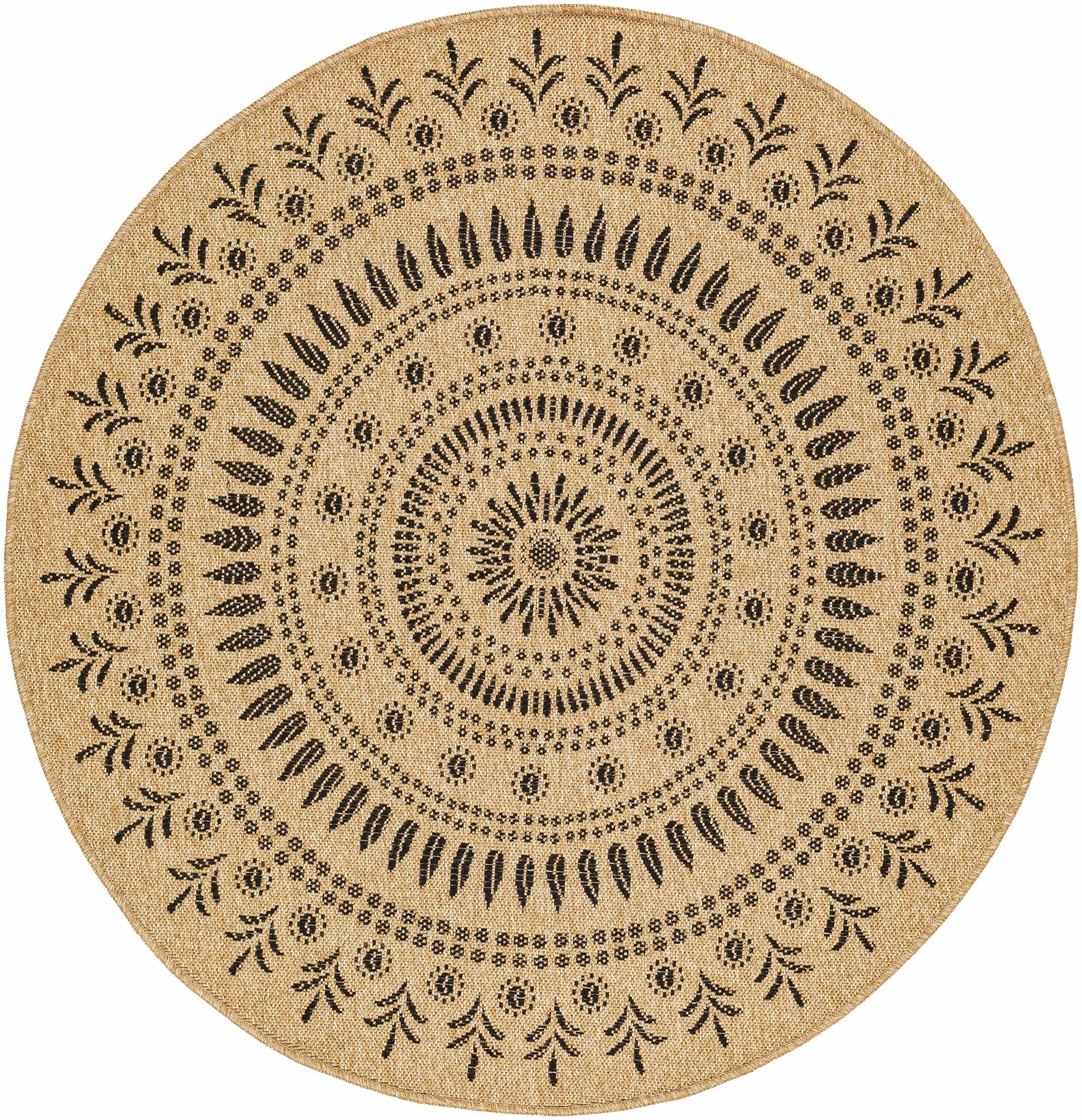Round farmhouse-style rug with black floral medallion pattern on beige woven background, cozy cottage decor